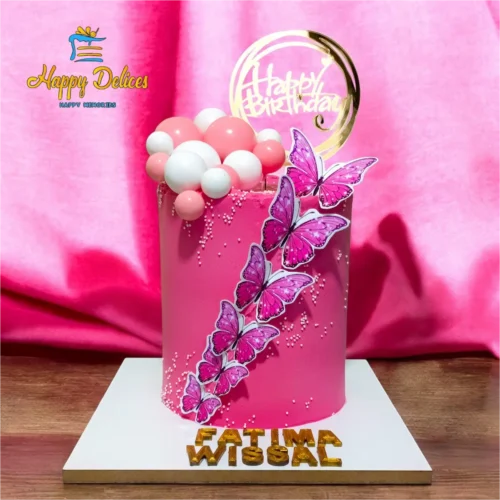 Pink birthday cake with butterfly decorations and balloon accents by Happy Delices