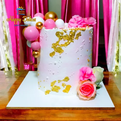 Pink and gold elegant birthday cake decorated with flowers and golden leaf by Happy Delices