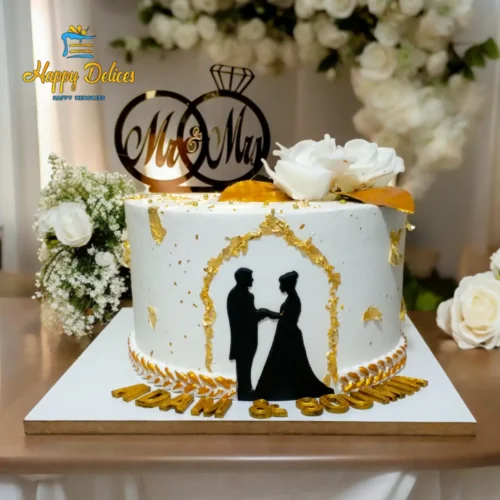 Elegant engagement cake with a black silhouette couple, gold arch accents, and white floral details by Happy Delices