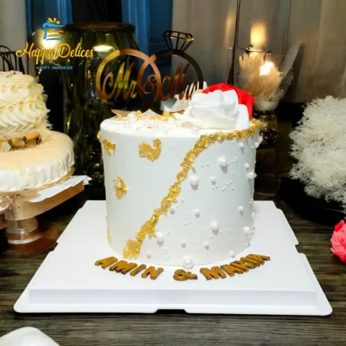 Elegant engagement cake with pearl details, torn gold accents, and white and red roses by Happy Delices