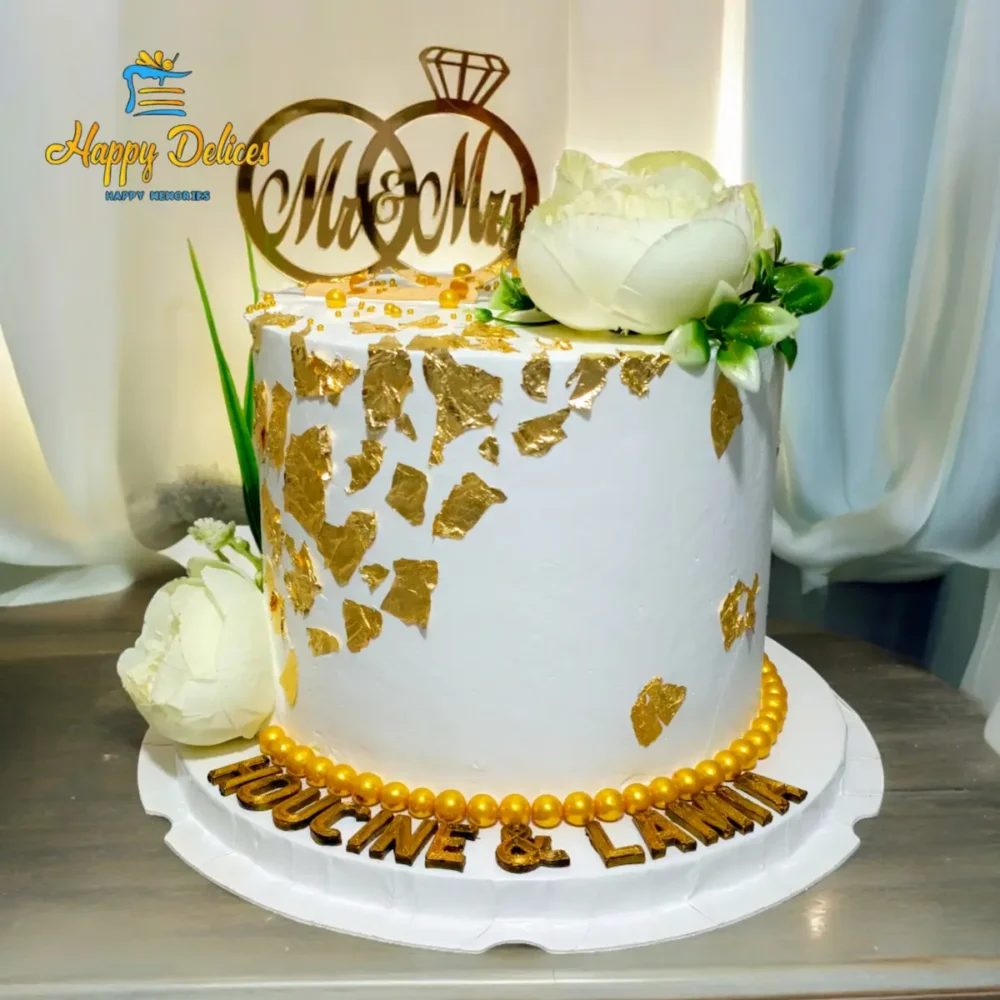 White & Gold Luxury Engagement Cake | Happy Delices Elegant white engagement cake with torn gold accents, white flowers, and golden pearls by Happy Delices