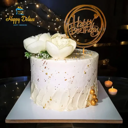 White & Gold Modern Birthday Cake | Happy Delices Elegant white birthday cake with gold splashes, white flowers, and gold spherical decorations by Happy Delices