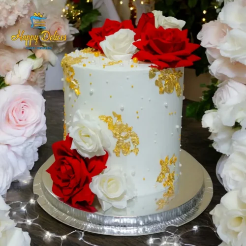 Elegant engagement cake with red and white roses, pearl-like details, and gold textured accents by Happy Delices