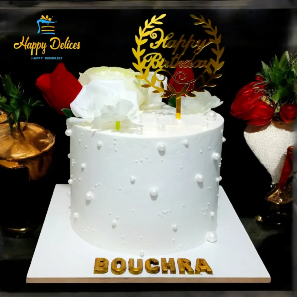 Elegant white birthday cake with pearl-like details and red and white roses by Happy Delices