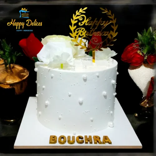 Elegant white birthday cake with pearl-like details and red and white roses by Happy Delices