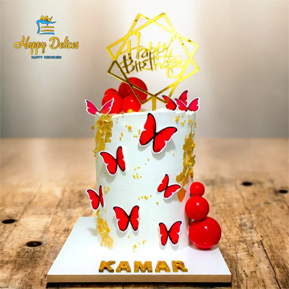 Elegant white birthday cake with red butterflies and gold leaf by Happy Delices