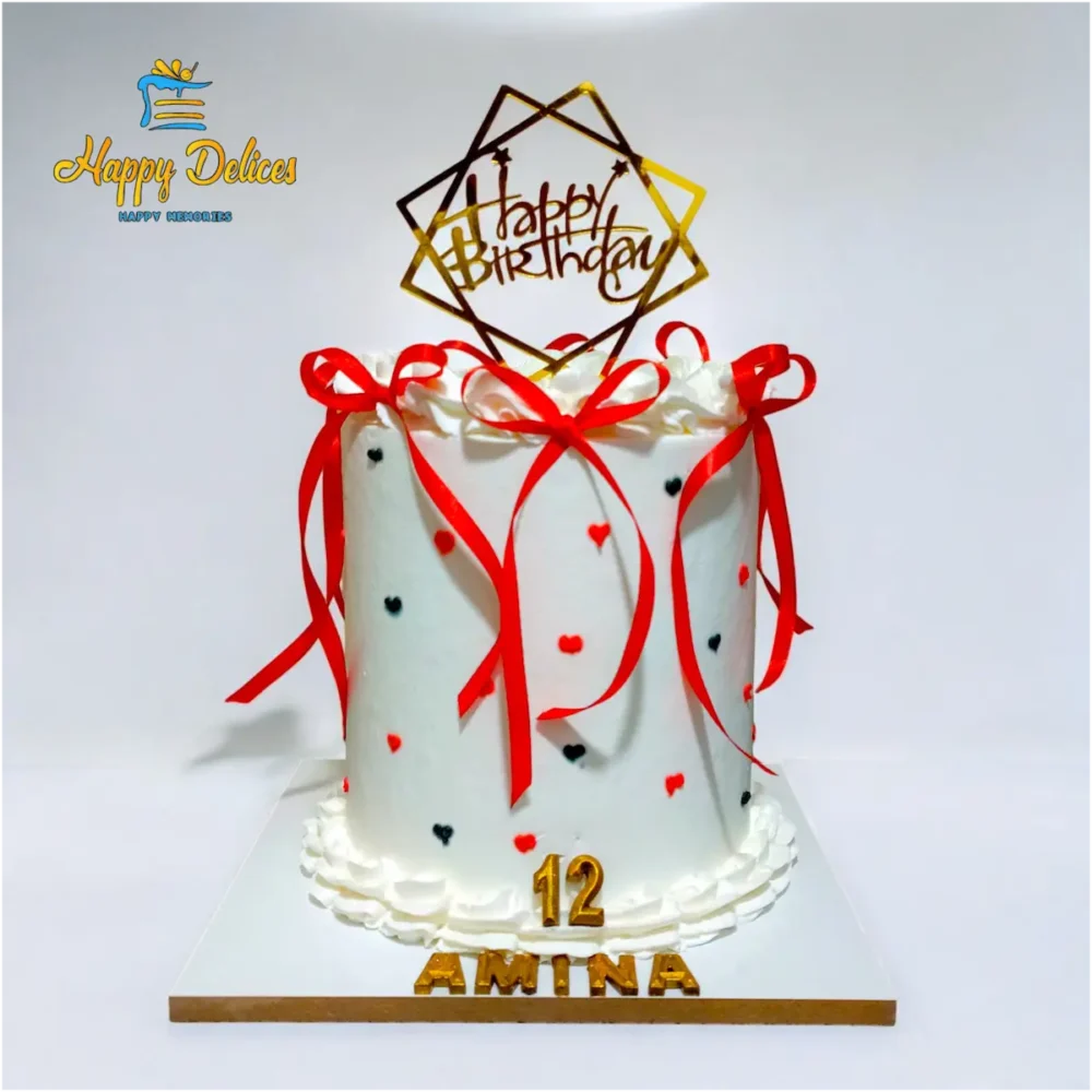 White cake with red ribbons and small heart decorations by Happy Delices