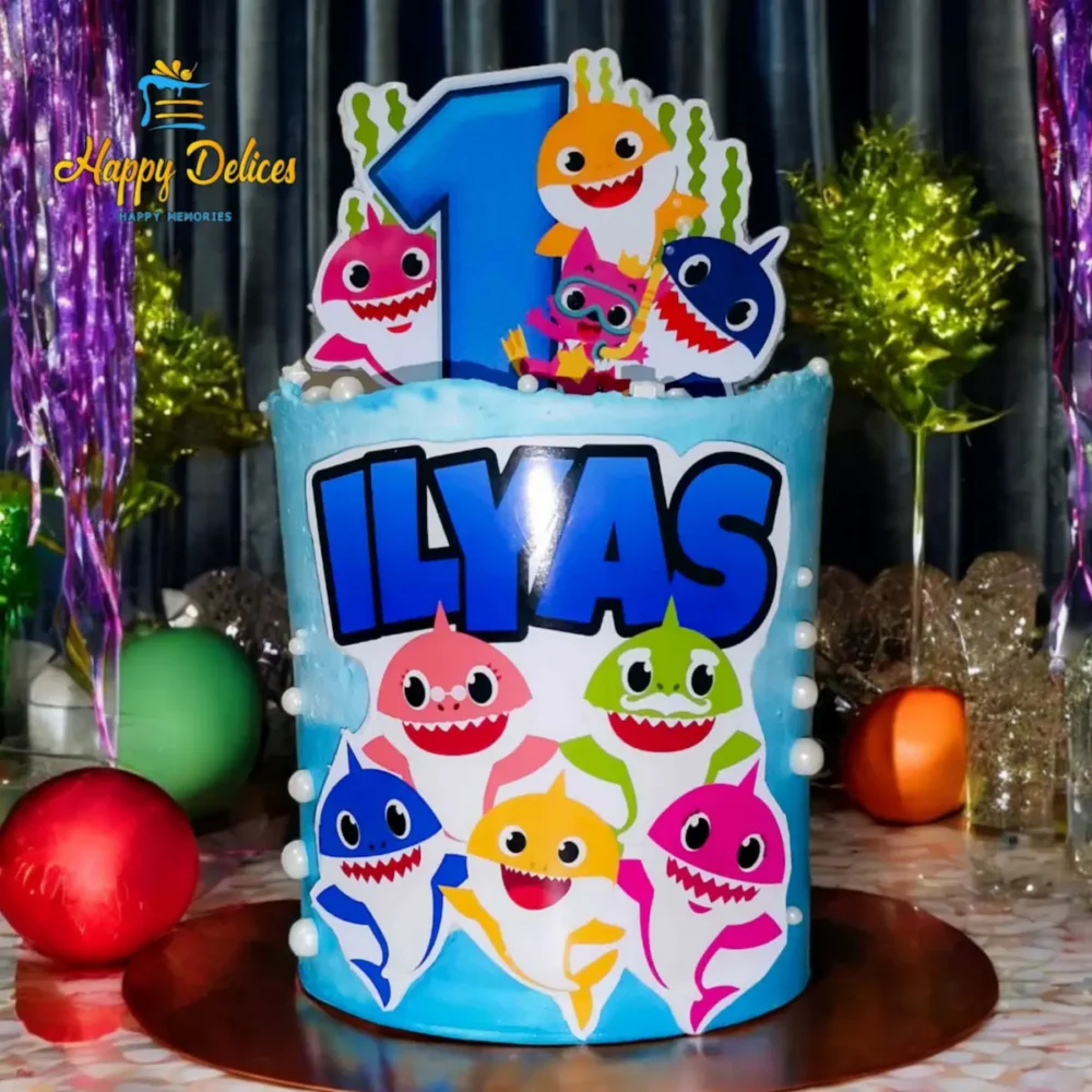 Baby Shark themed blue birthday cake with number one topper and personalized name by Happy Delices