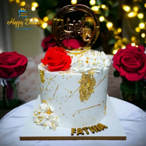 Elegant white and gold birthday cake with red roses and personalized name topper by Happy Delices