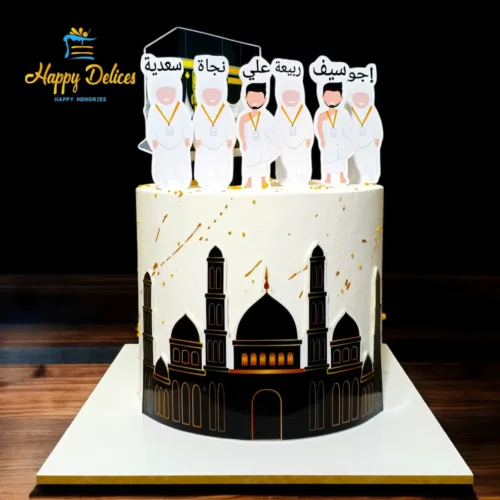 Umrah family celebration cake with Kaaba topper, mosque silhouette and gold accents by Happy Delices