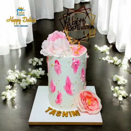 Elegant pink and white birthday cake with floral decoration and gold topper by Happy Delices