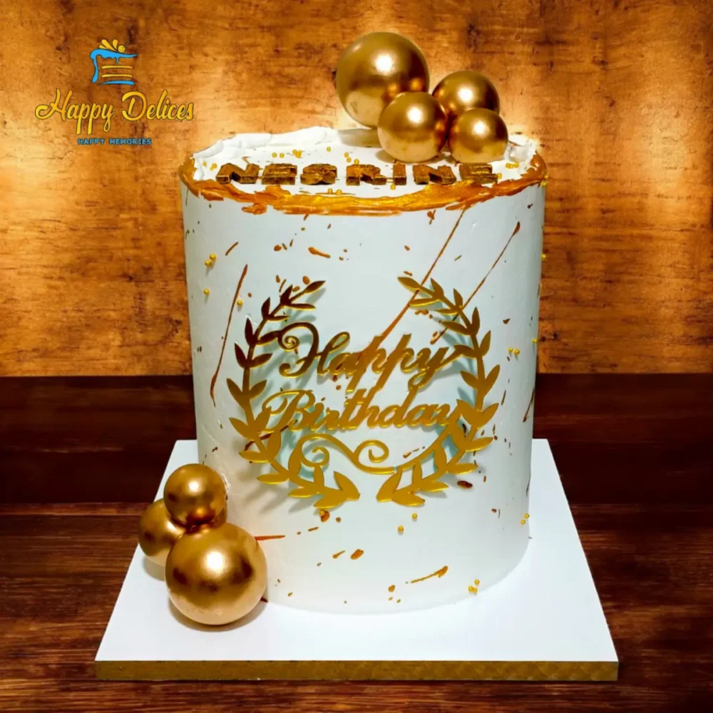 Elegant white and gold birthday cake with classic design and decorative spheres by Happy Delices