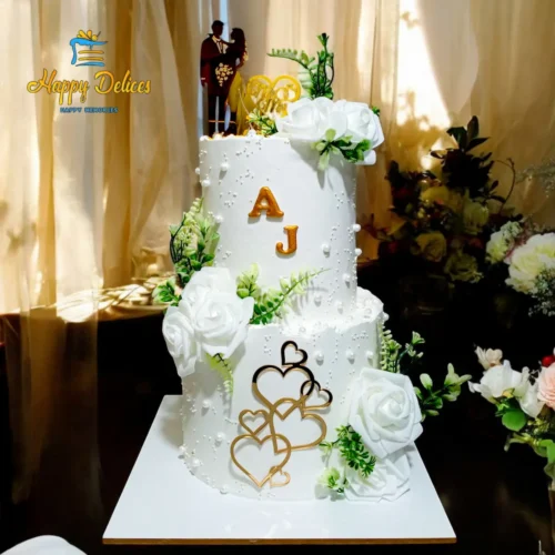 Elegant white wedding cake with gold details, flowers and romantic topper by Happy Delices
