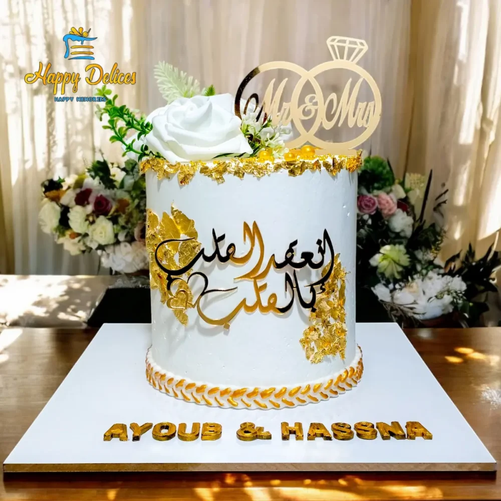 Elegant white and gold engagement cake with Arabic calligraphy and custom names by Happy Delices