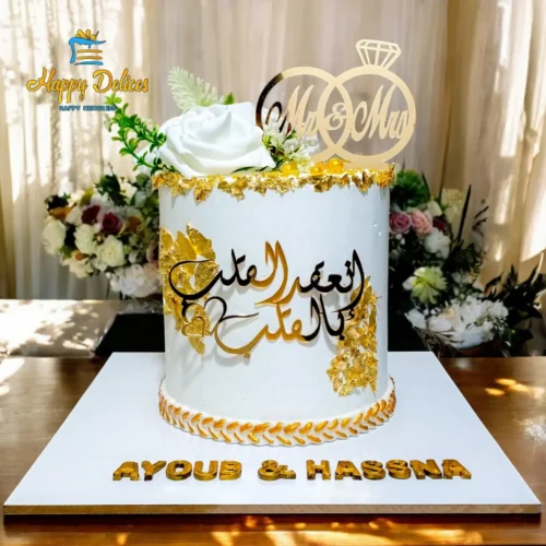 Elegant white and gold engagement cake with Arabic calligraphy and custom names by Happy Delices
