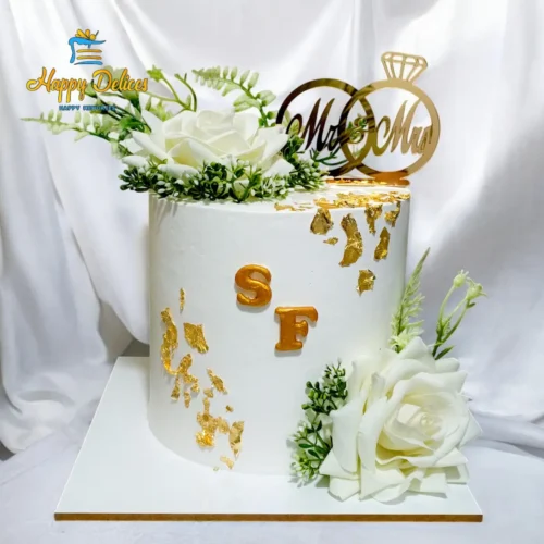 Minimalist white wedding cake with gold leaf, flowers and ring topper by Happy Delices